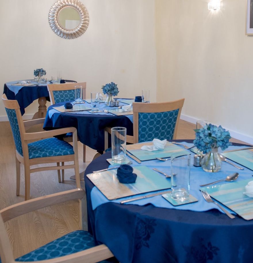 dining room with blue chairs and blue tablecloths